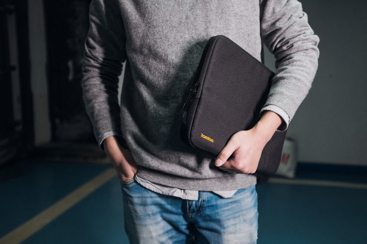 Hombre llevando una funda tomtoc para notebook